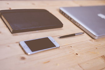 Minimalist Workspace with Smartphone, Laptop, and Notebook on Wood