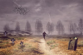Lonely man walking through misty graveyard with tombstones