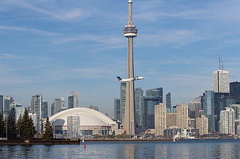 Toronto Skyline With CN Tower And Airplane Over Water