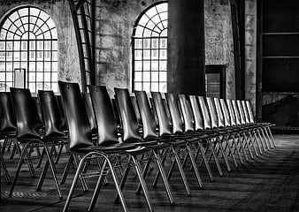 Rows of Empty Black Chairs in Industrial Hall
