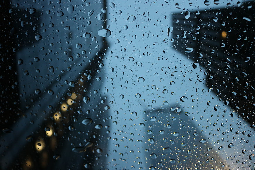 Raindrops on Window with Blurred City Lights Background