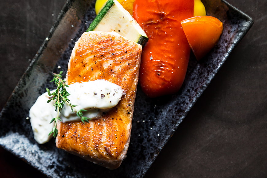 Grilled Salmon Fillet with Vegetables on Dark Plate