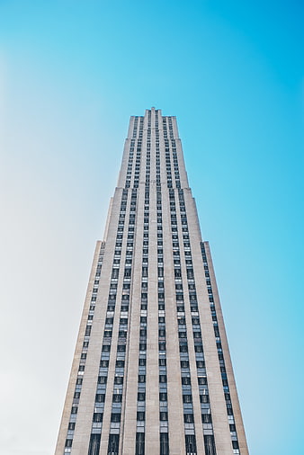 Low angle view of tall skyscraper against blue sky