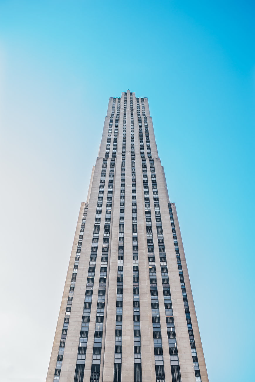 Low angle view of tall skyscraper against blue sky