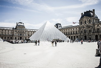 Wide shot of the Louvre Pyramid and museum courtyard in Paris