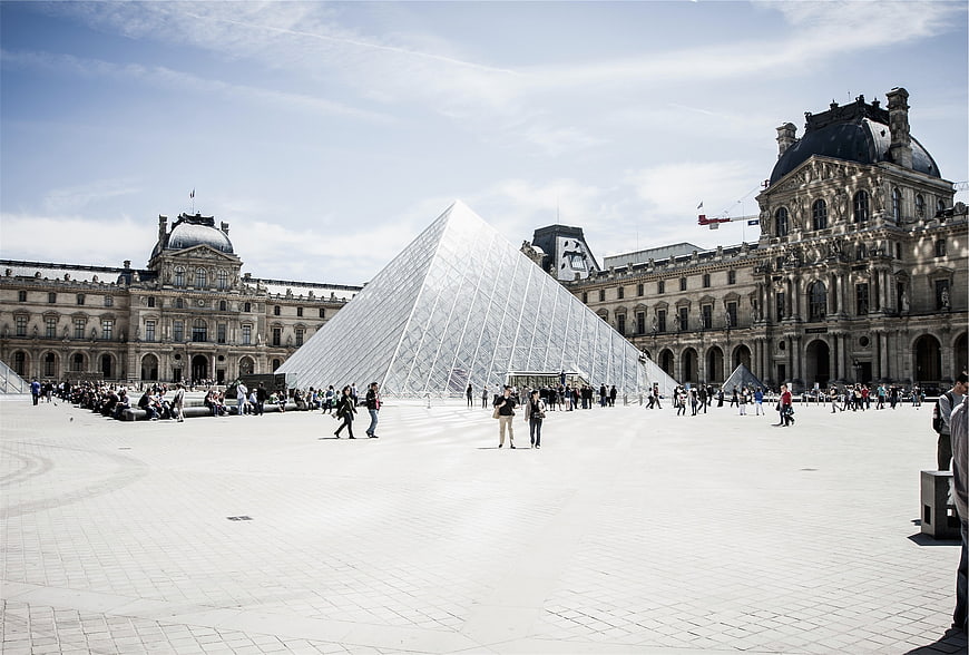 Wide shot of the Louvre Pyramid and museum courtyard in Paris