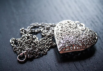Silver Filigree Heart Locket Necklace On Dark Wood