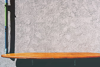Wooden Surfboard Shelf on Textured Concrete Wall