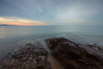 Serene Long Exposure Rocky Coastline at Sunset