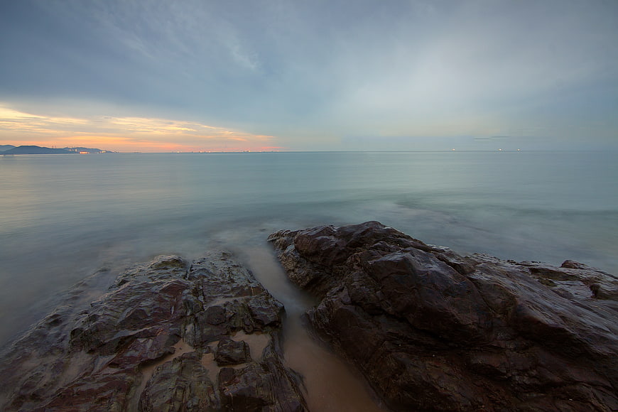 Serene Long Exposure Rocky Coastline at Sunset