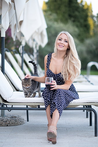 Blonde Woman Relaxing with Cat and Wine by Pool