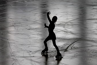 Silhouette of female figure skater on ice rink