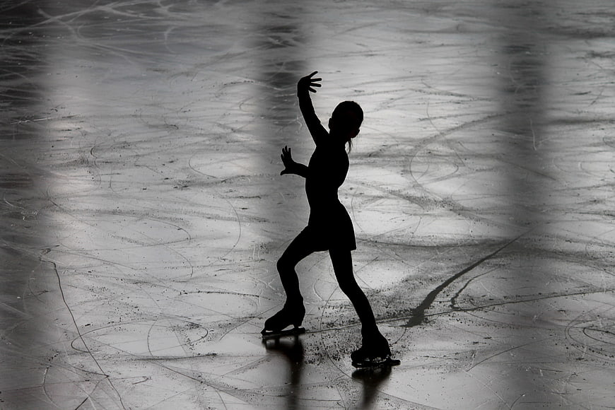Silhouette of female figure skater on ice rink