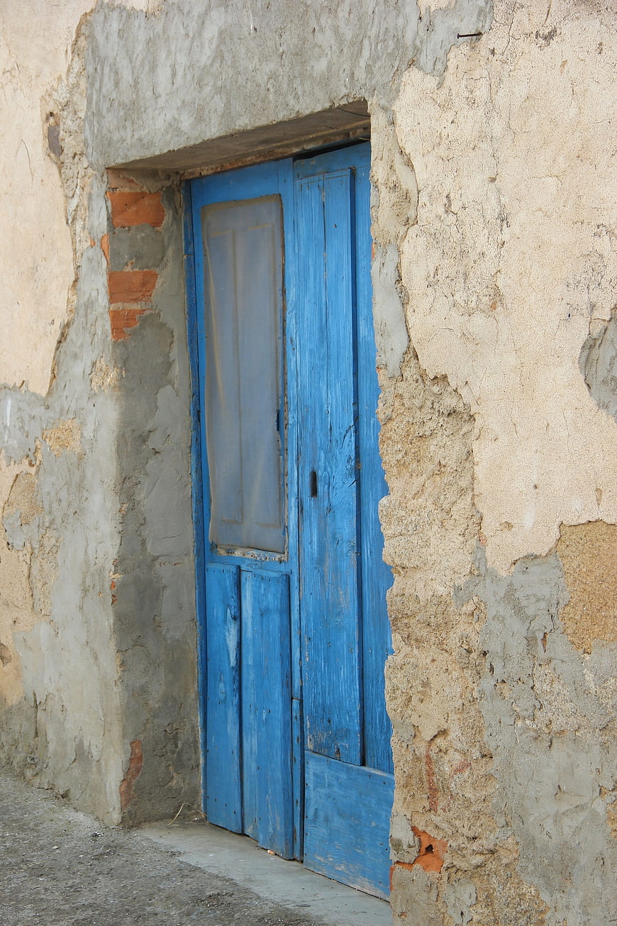 Weathered Blue Wooden Door in Old Spanish Village Wall