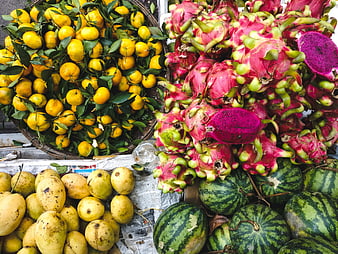 Top view of fresh dragon fruit, tangerines, mangoes, and watermelons