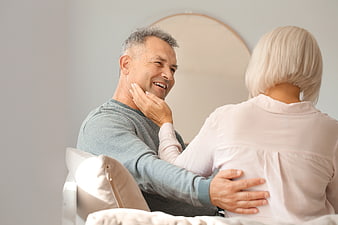 Happy Senior Couple Embracing on Sofa at Home