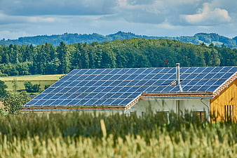 Solar Panels on Rural House Roof with Green Hills