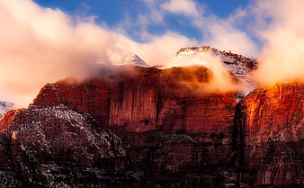Snowy Red Rock Cliffs with Dramatic Clouds at Sunset