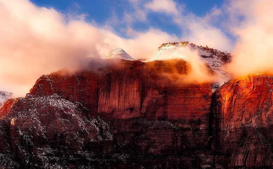 Snowy Red Rock Cliffs with Dramatic Clouds at Sunset