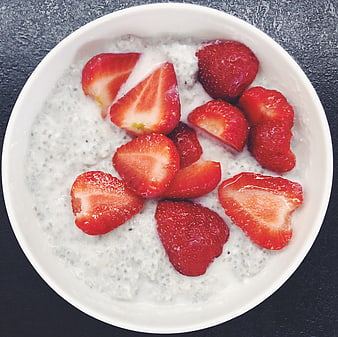 Overhead view of chia pudding with fresh strawberries in white bowl