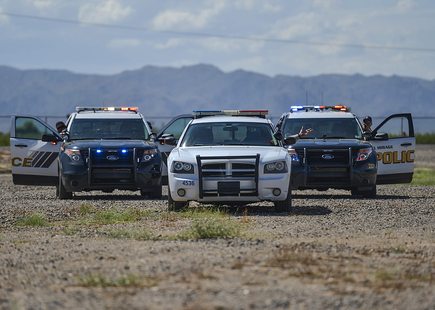 Police cars with lights on in desert landscape