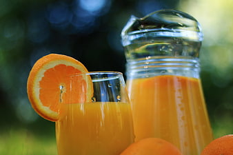 Fresh Orange Juice in Glass and Pitcher with Slice Garnish