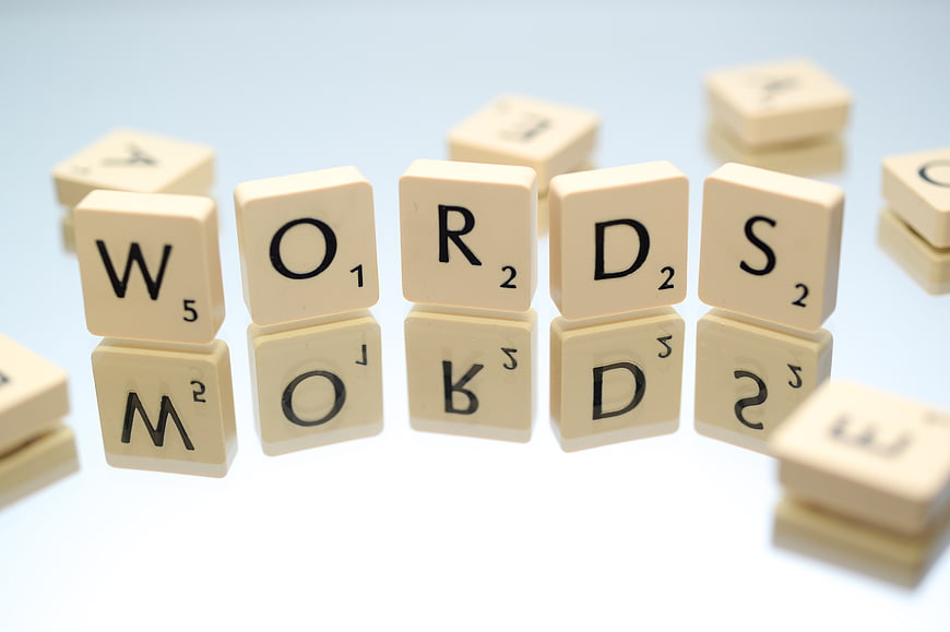 Scrabble Tiles Spelling Words on White Background