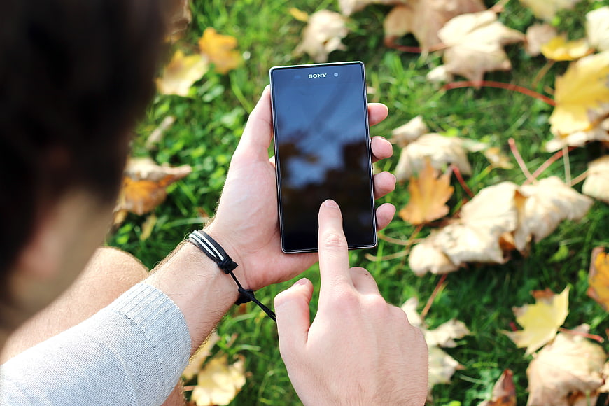 Man using smartphone in autumn park