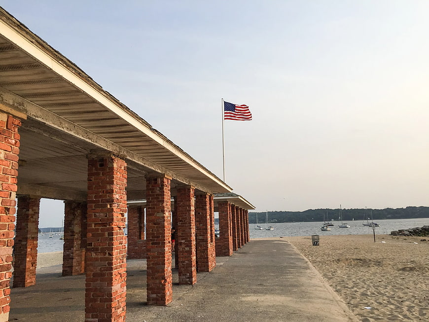 American Flag Flying Over Brick Pier and Beach