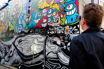 Man Viewing Colorful Street Art and Graffiti Wall