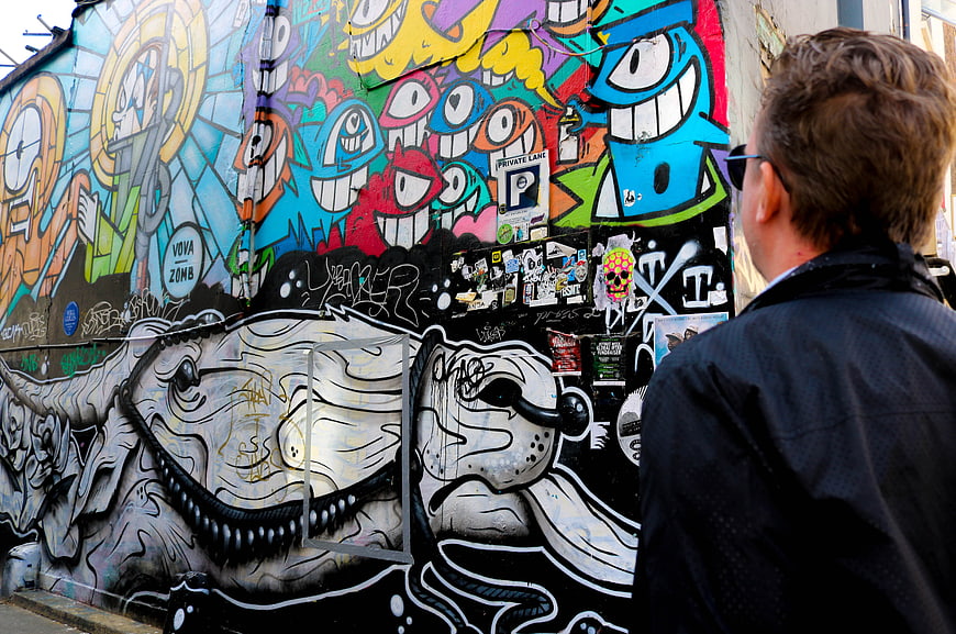 Man Viewing Colorful Street Art and Graffiti Wall