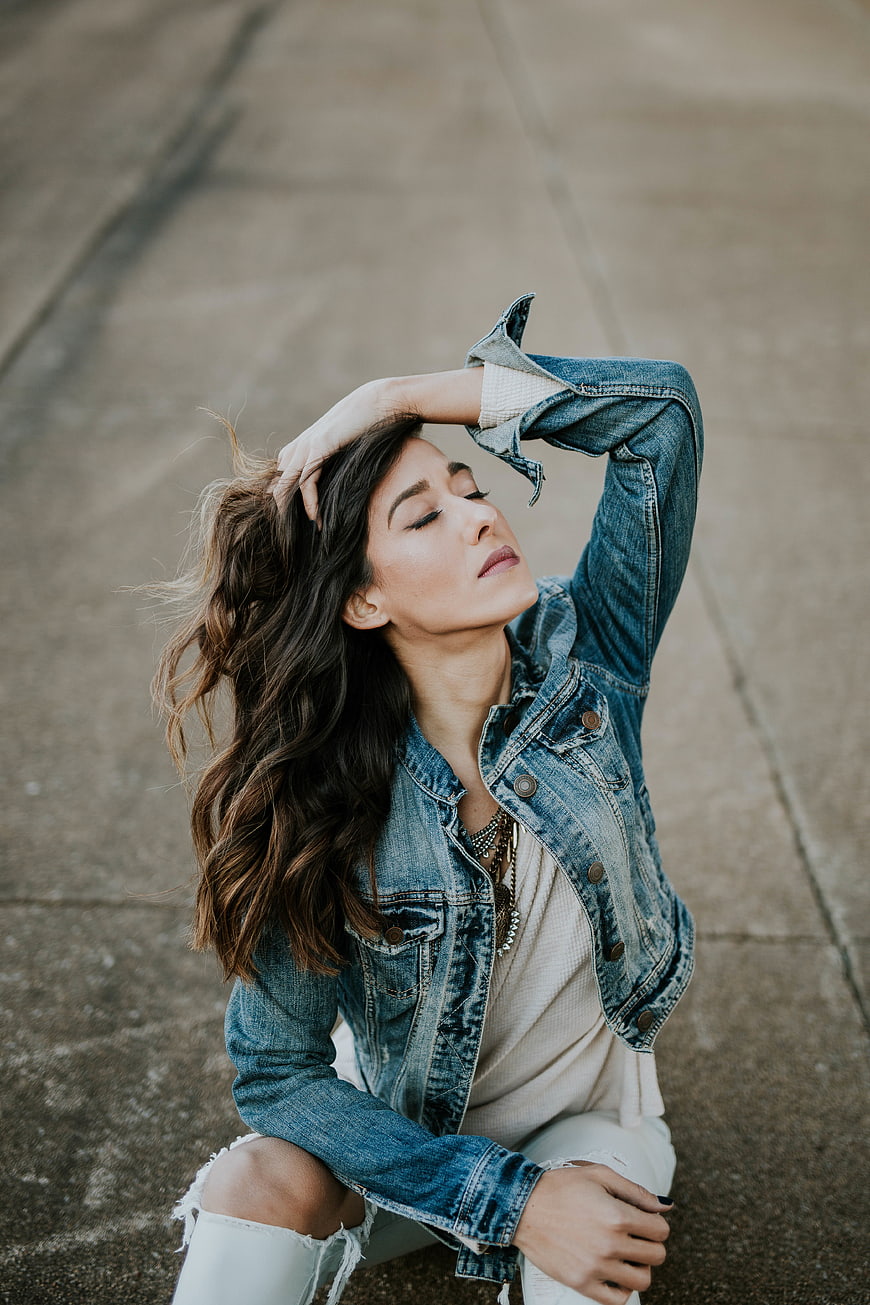 Woman in Denim Jacket Sitting on Concrete Road