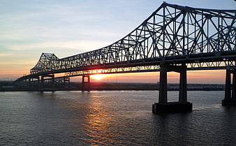 Steel Truss Bridge Silhouette Over River At Sunrise