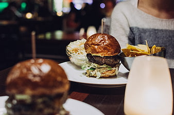 Juicy beef burger with coleslaw and chips in a restaurant