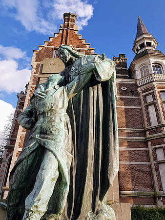 Bronze Pieta Statue in Front of Brick Church Architecture