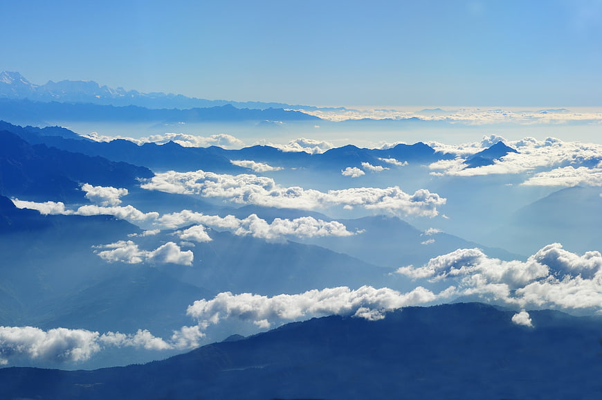 Majestic Himalayan mountain range with clouds and sunbeams