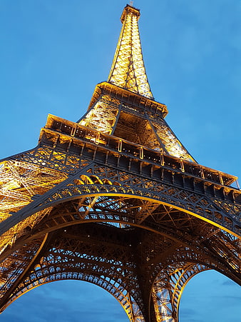 Low angle view of illuminated Eiffel Tower at dusk