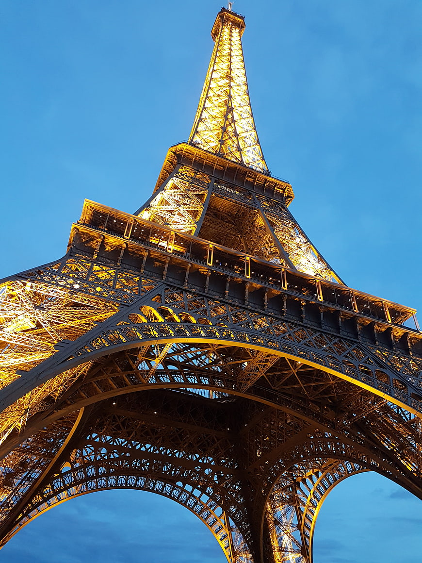 Low angle view of illuminated Eiffel Tower at dusk