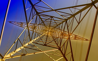 Low angle view of yellow electricity pylon against blue sky