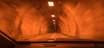 Motion blur view driving through illuminated orange tunnel