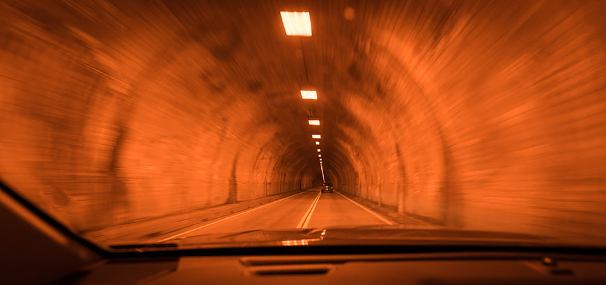Motion blur view driving through illuminated orange tunnel