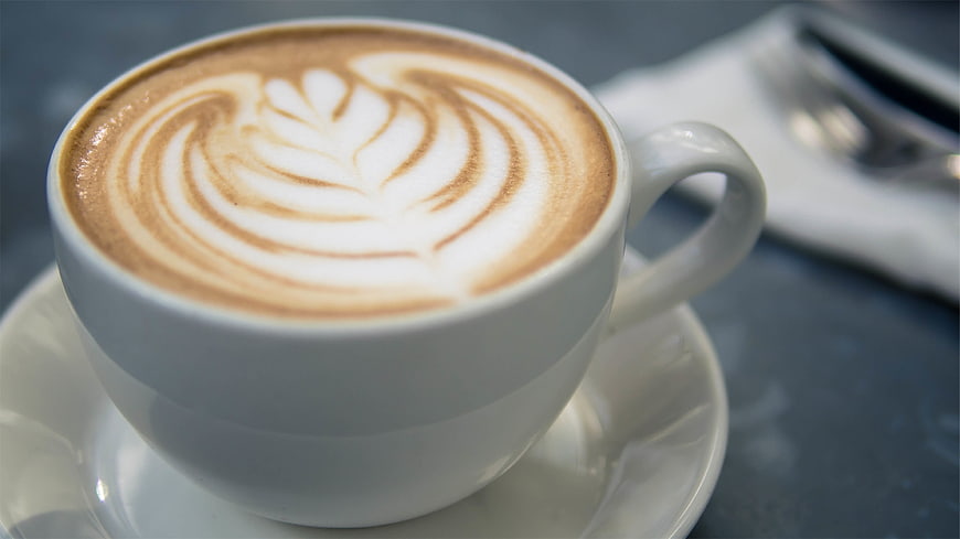 Close-up of Cappuccino with Intricate Latte Art in White Cup
