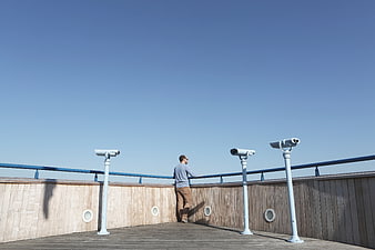 Man looking out from observation deck with binoculars