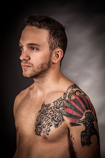 Studio Portrait of Young Man with Intricate Chest and Shoulder Tattoos