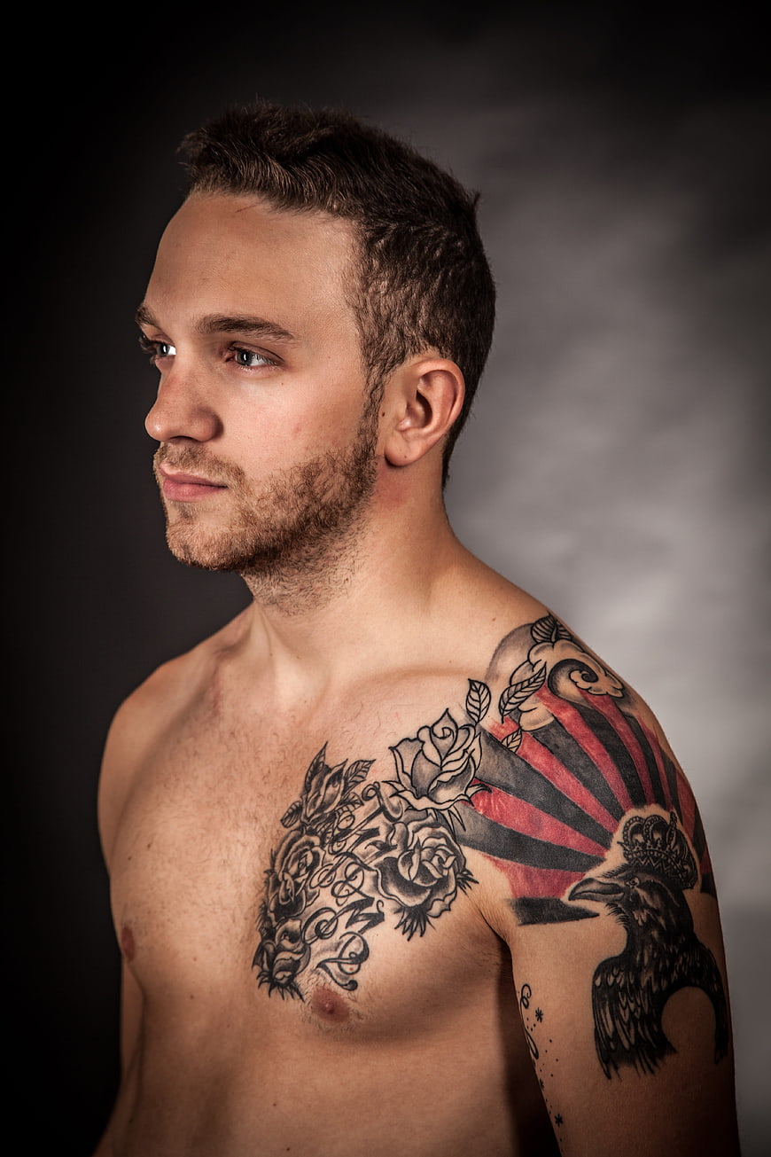 Studio Portrait of Young Man with Intricate Chest and Shoulder Tattoos