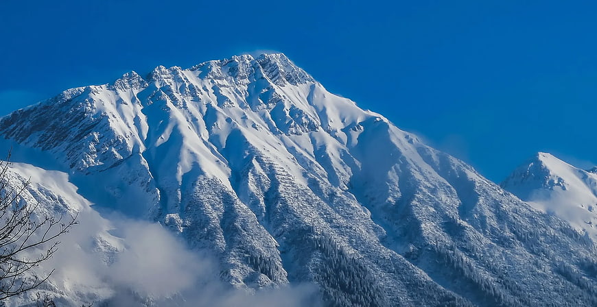 Majestic Snow-Capped Mountain Peak Against Blue Sky