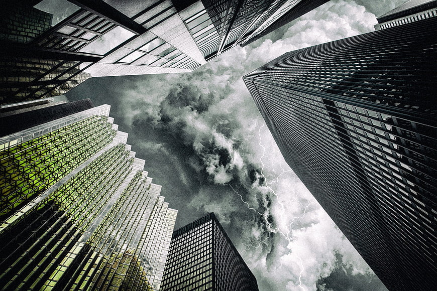 Dramatic low-angle view of skyscrapers with lightning storm