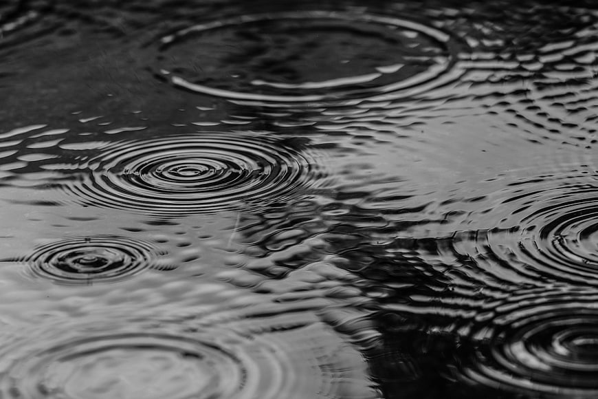 Black and white rain ripples in a puddle