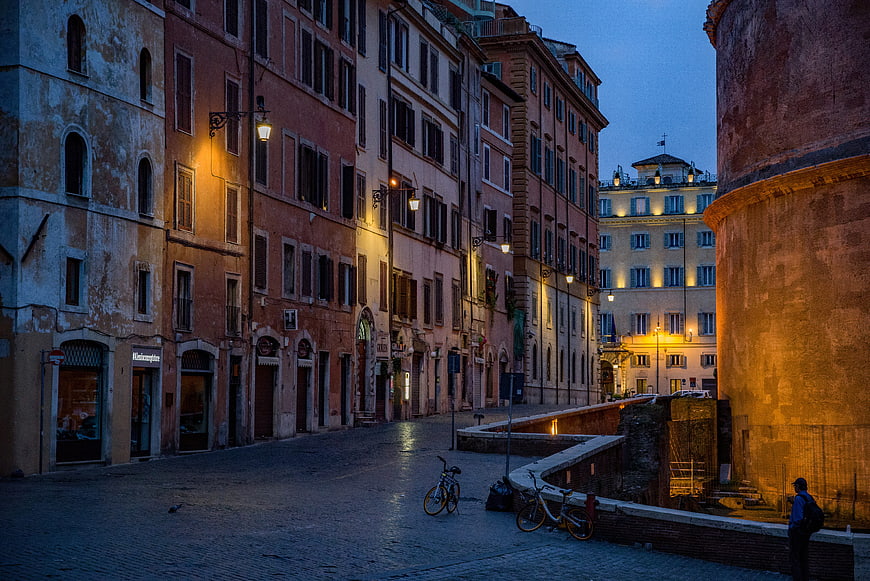 Empty cobblestone street in Rome at dusk with historic architecture