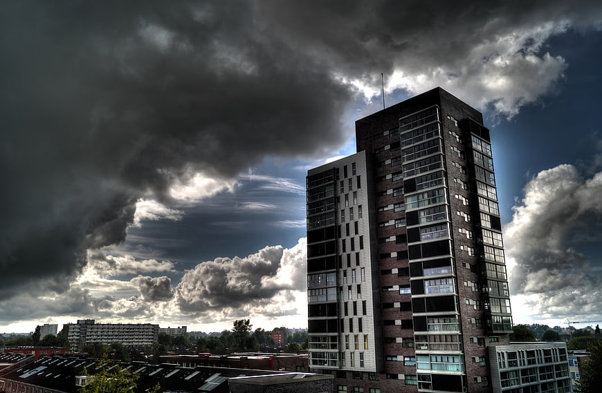 Modern High-Rise Apartment Building Under Dramatic Stormy Sky